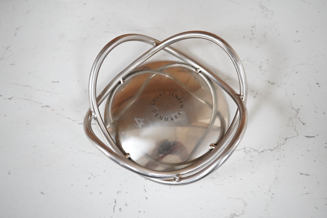 A pair of Georg Jensen stainless steel Cobra candleholders and a Georg Jensen Glow candle, latter 10cm diameter.